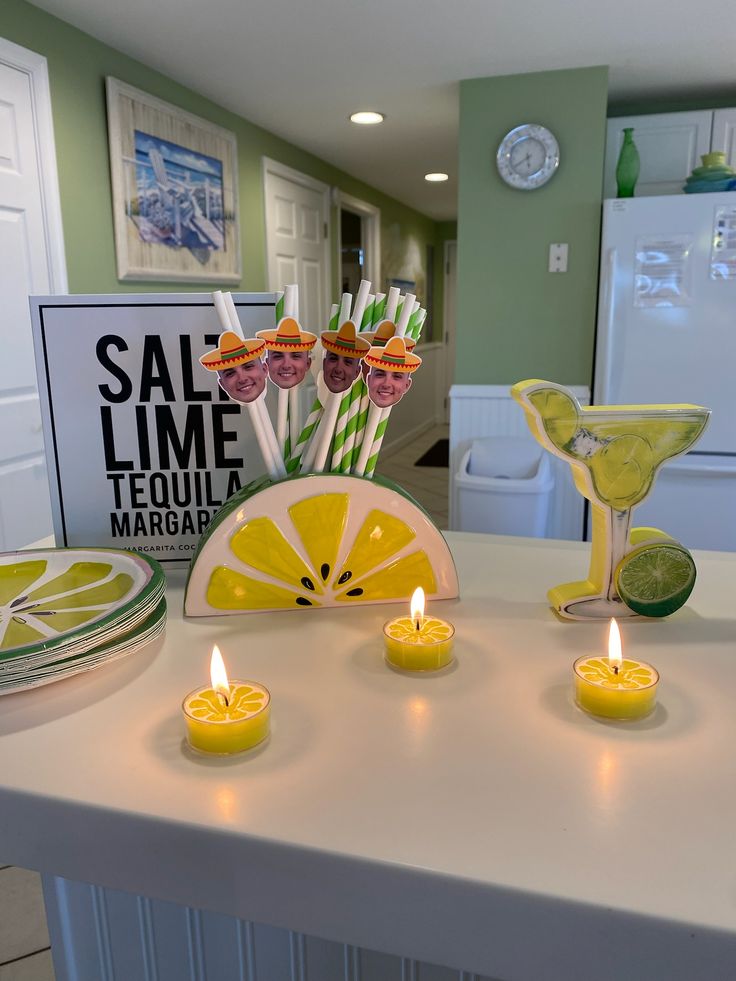 candles are lit on a table in front of a sign that says sal lime tequila margarita