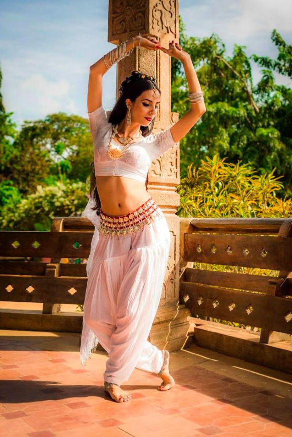 a woman in a white outfit is dancing