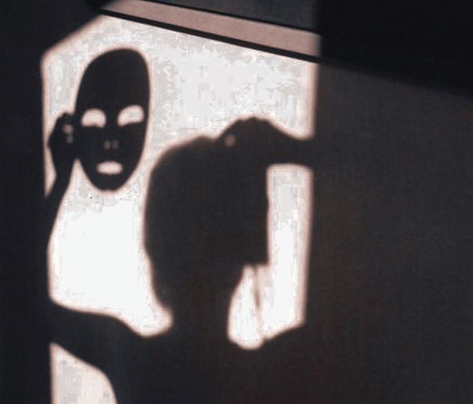 the shadow of a person with a mask on