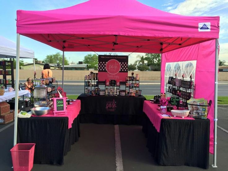 a pink tent is set up with black tablecloths and other items on it