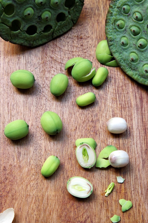 some green vegetables are sitting on a cutting board next to an egg shell and garlic