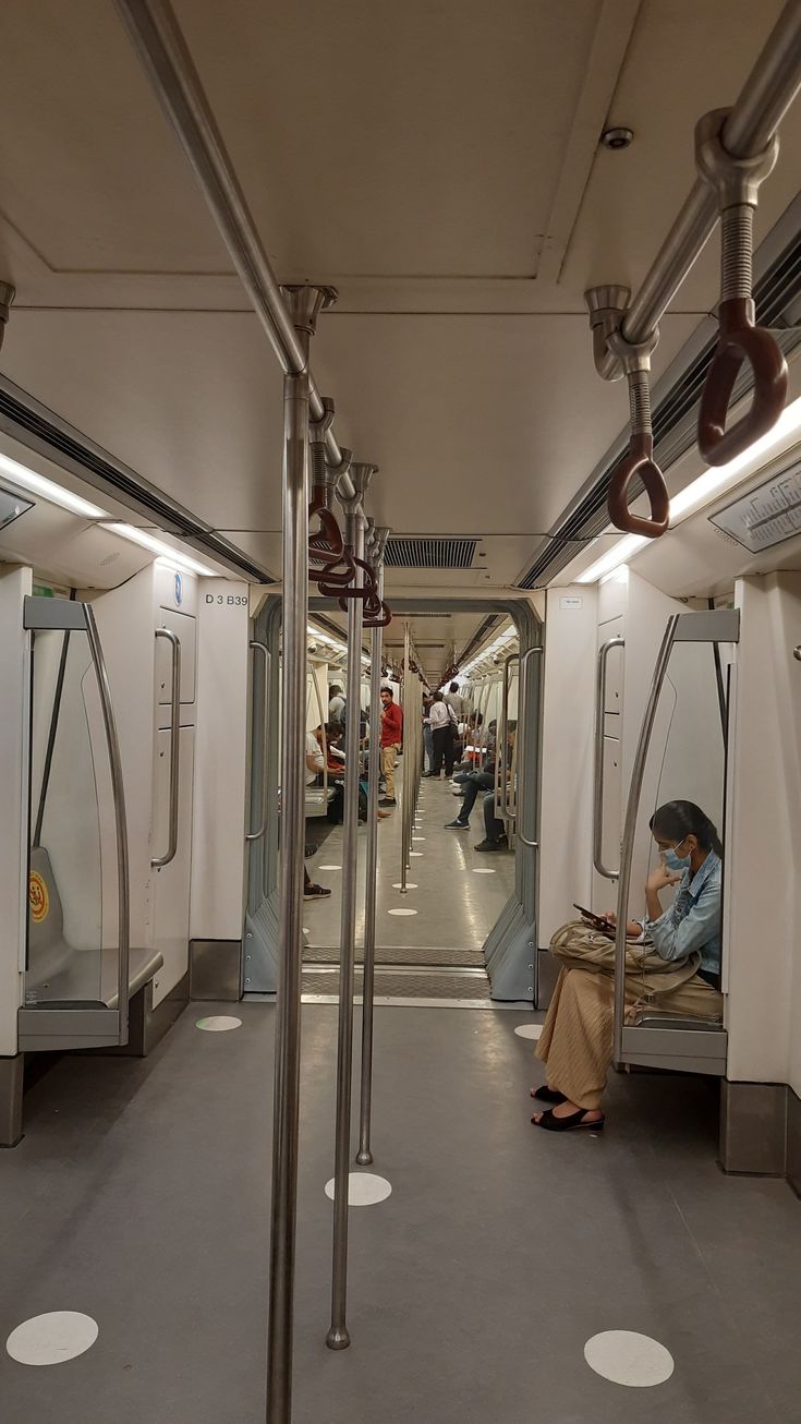 a person sitting on a bench in a subway car with lots of mirrors around them