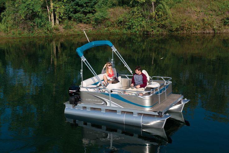 three people are sitting on the back of a silver pontoon boat in the water