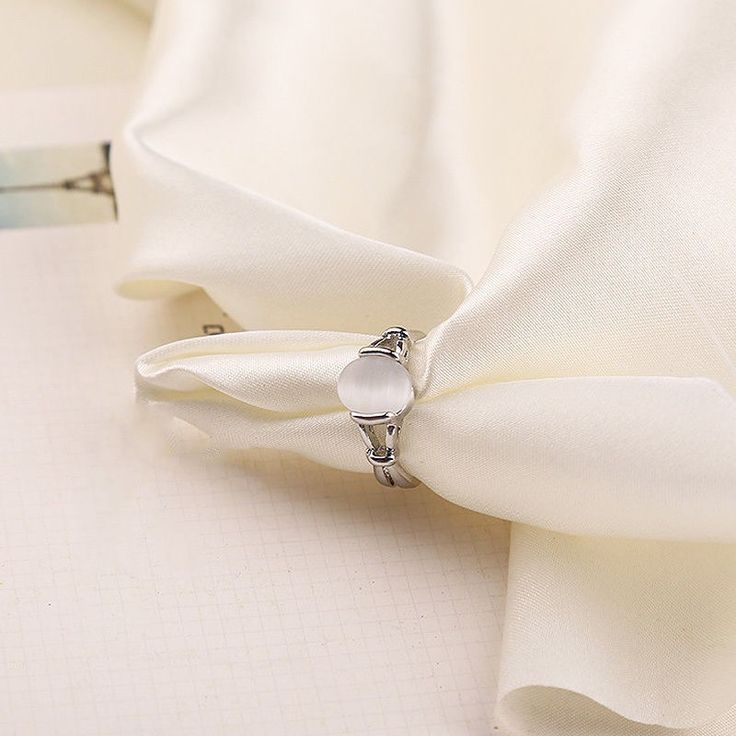 a close up of a white cloth with a ring on it's center piece