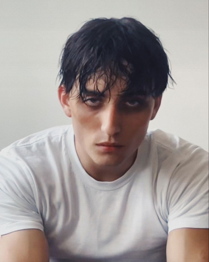 a young man with black hair and white shirt