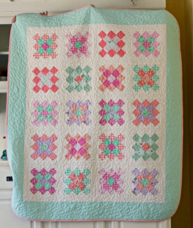 a quilt hanging from the side of a white radiator next to a book shelf