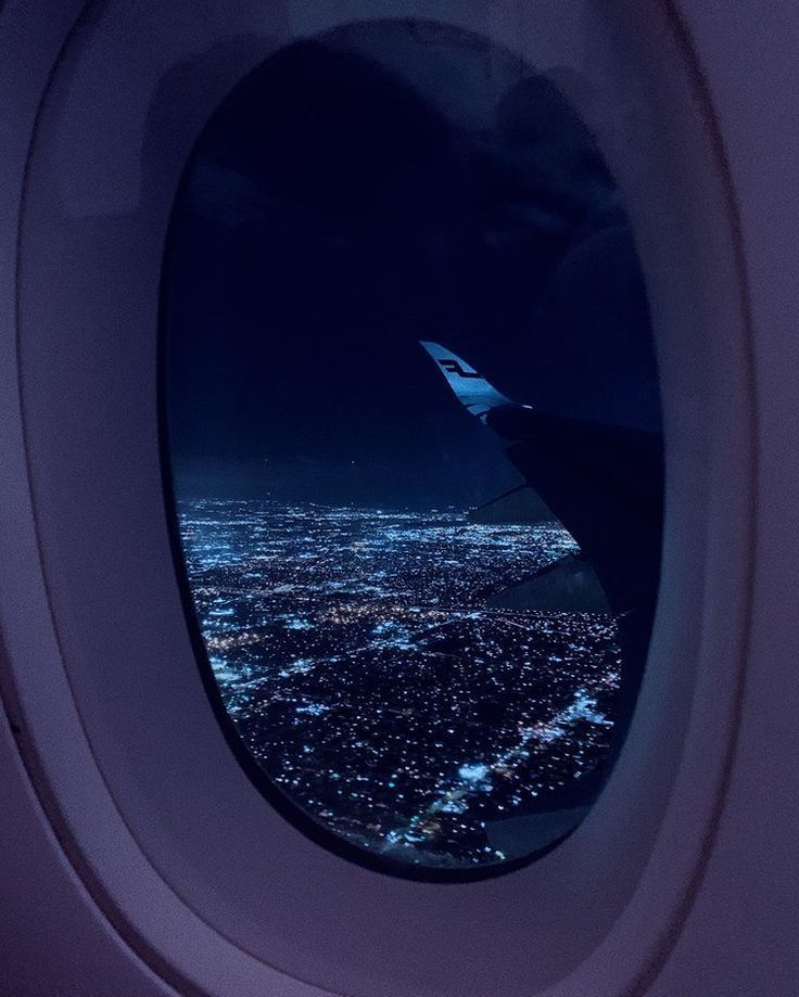 an airplane window looking out at the city lights