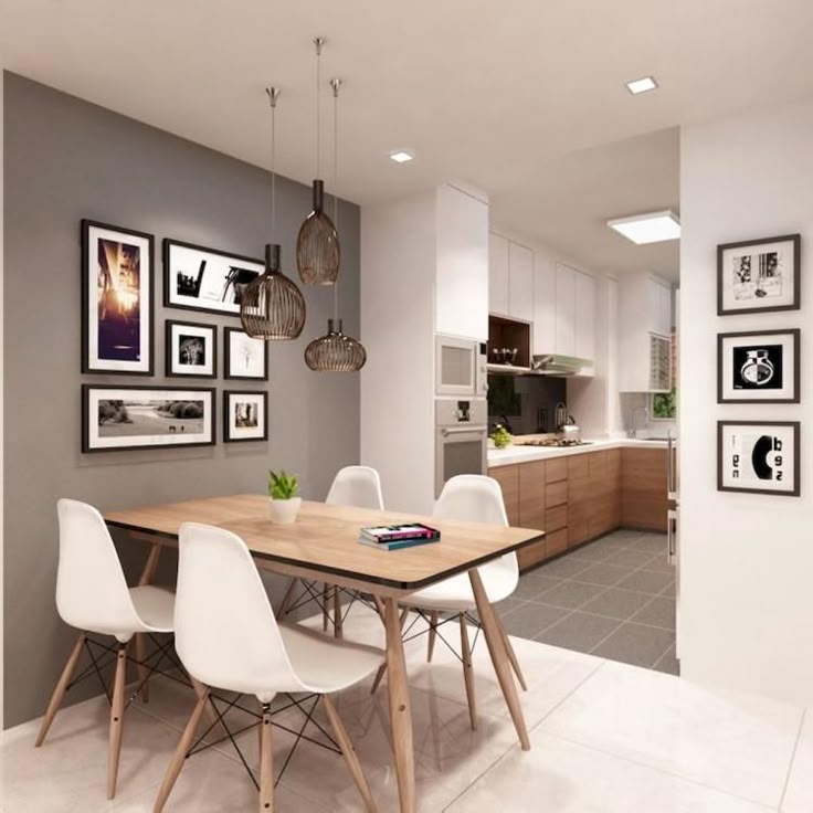 a dining room table with white chairs and pictures hanging on the wall above it in front of an open kitchen