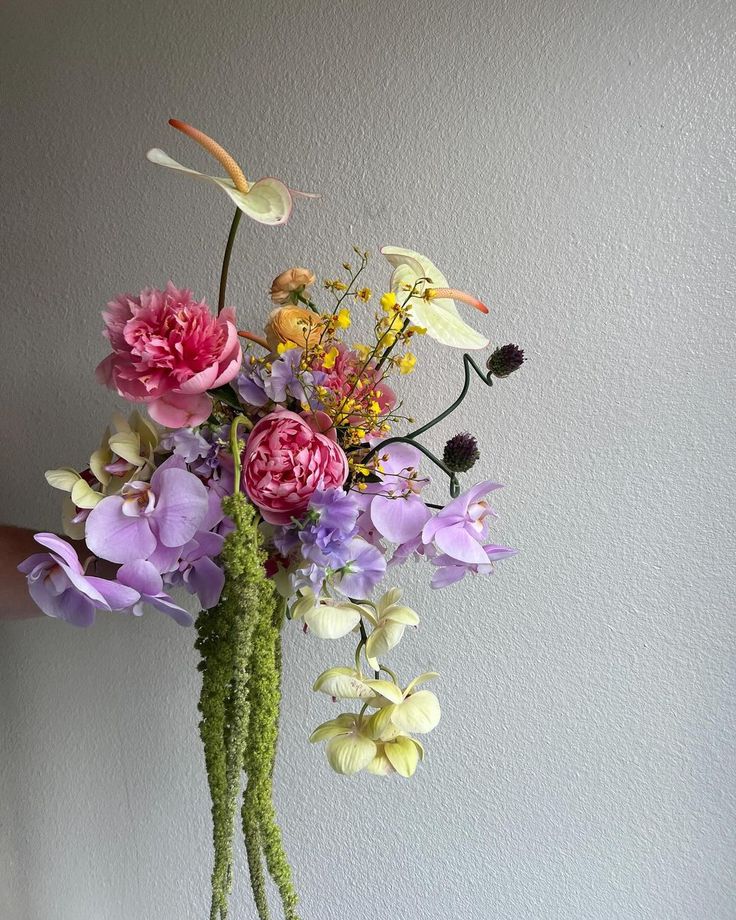 a vase filled with lots of different colored flowers