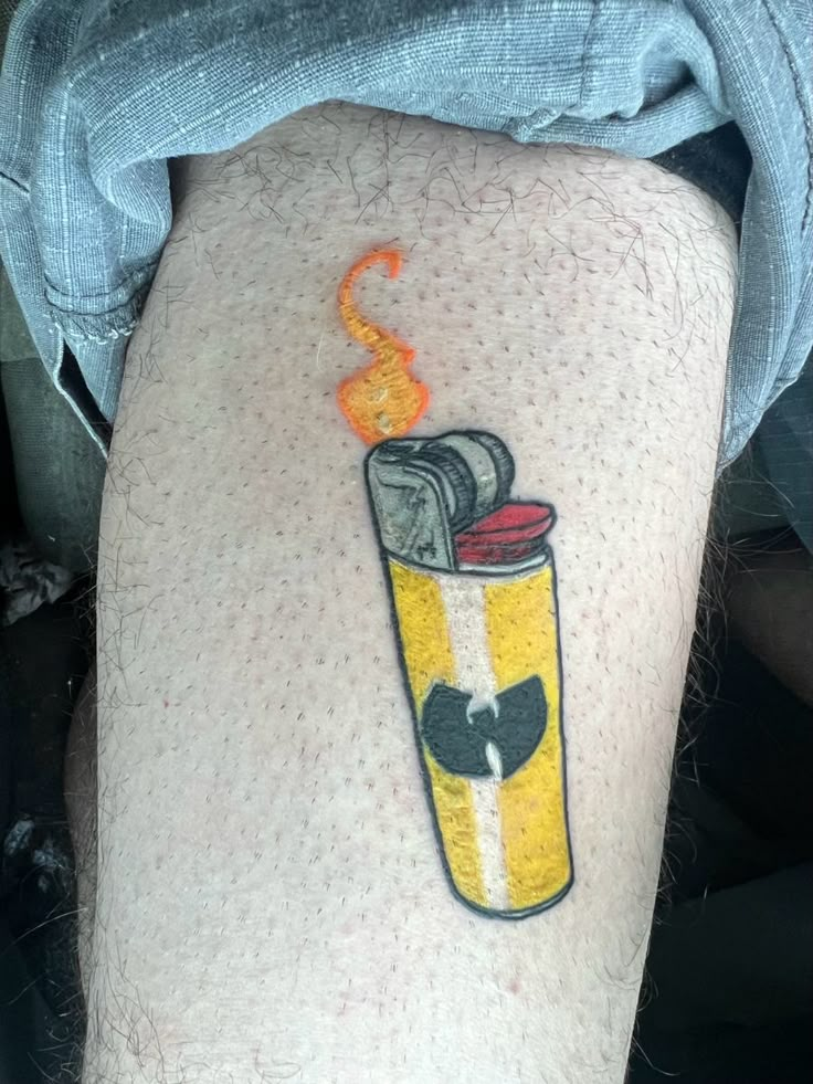 a person with a tattoo on their leg that has a lighter in the middle of it