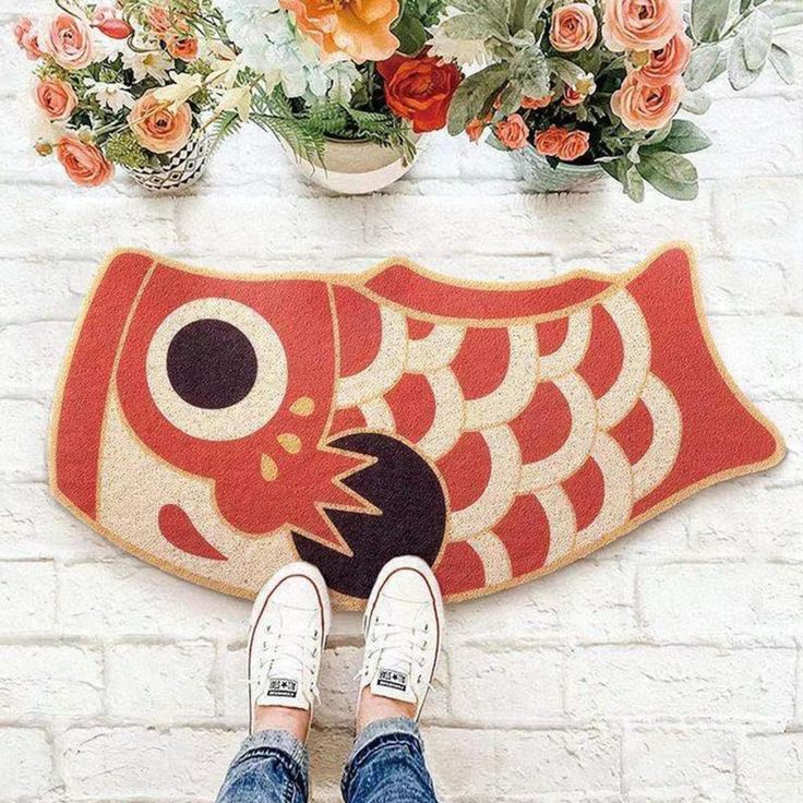 a person standing in front of a rug with an image of a fish on it