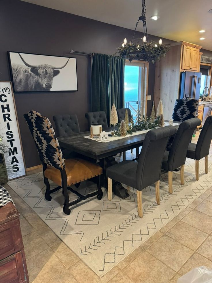 the dining room table is set with black chairs and an animal print rug on the floor