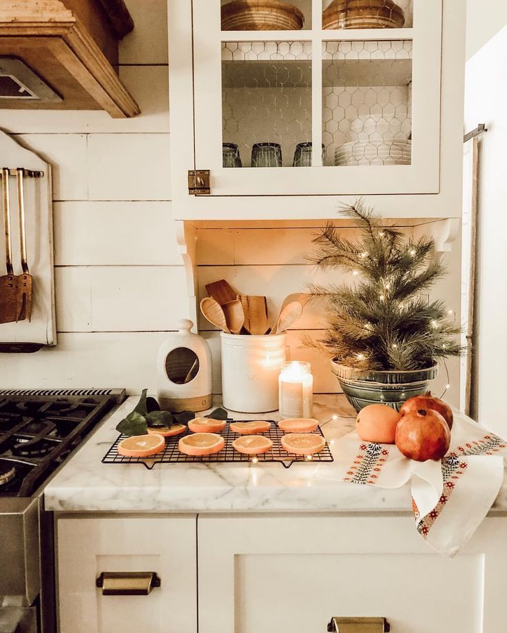 a kitchen counter topped with cookies next to a potted plant and lit candle on top of it