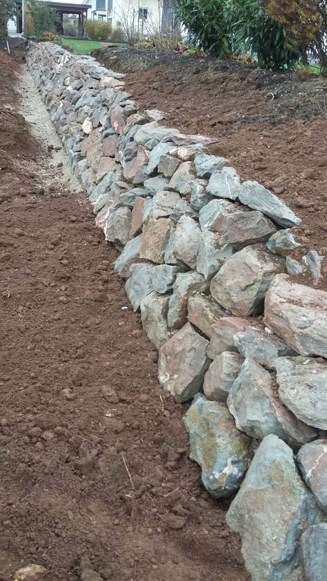 a stone wall in the middle of a field