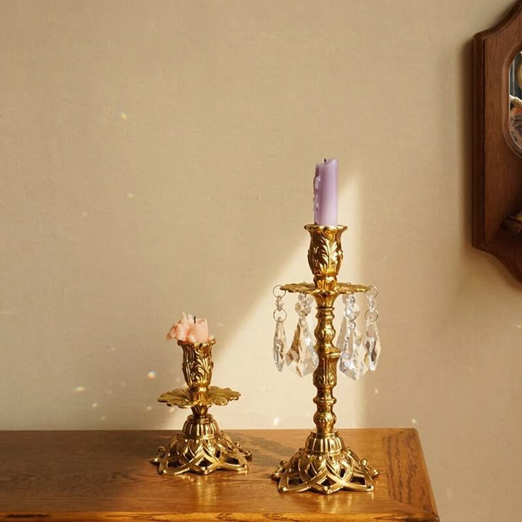 two golden candlesticks on a wooden table