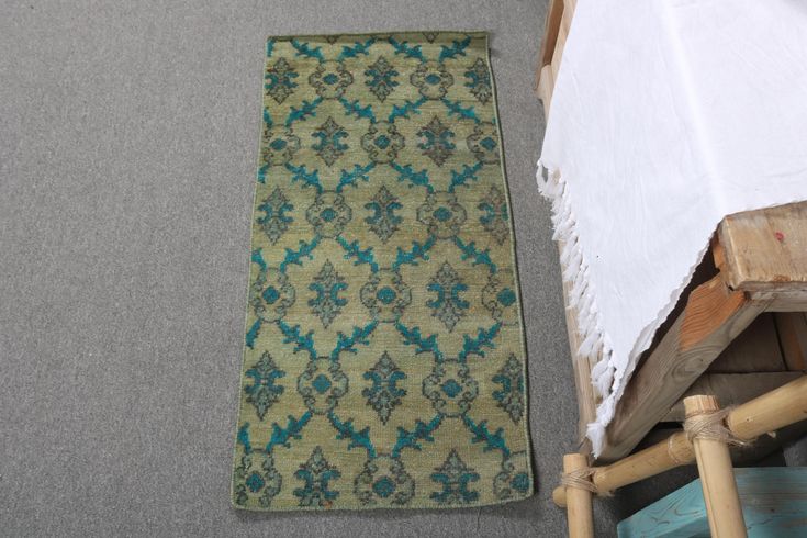 an old rug is laying on the floor next to a wooden chair and bed frame