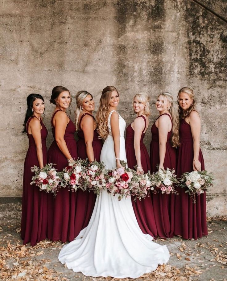 the bride and her bridesmaids are all wearing burgundy dresses