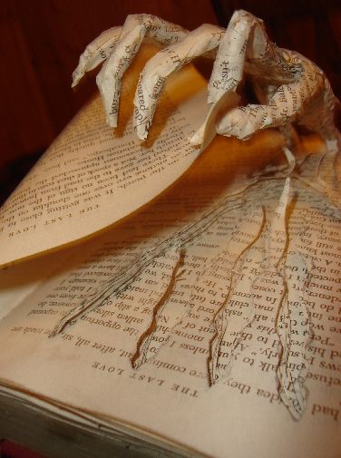 an open book with torn pages sitting on top of it