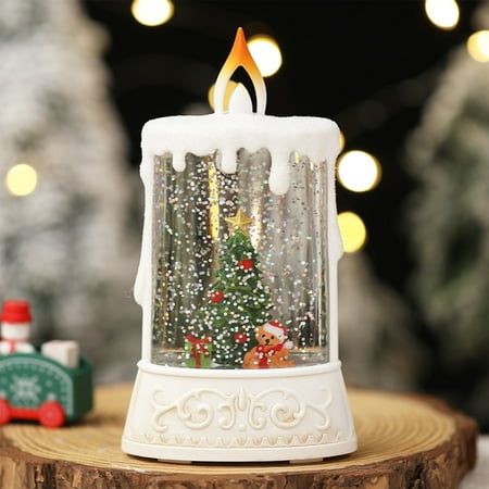 a small white candle with a christmas tree in the center on top of a wooden table