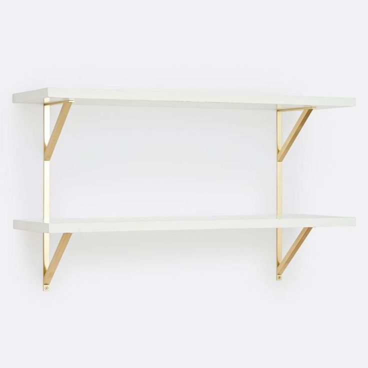 three white shelves with gold trim on each shelf, one is empty and the other has two