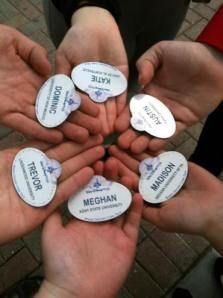 several people holding their hands together in the shape of a circle with labels on them