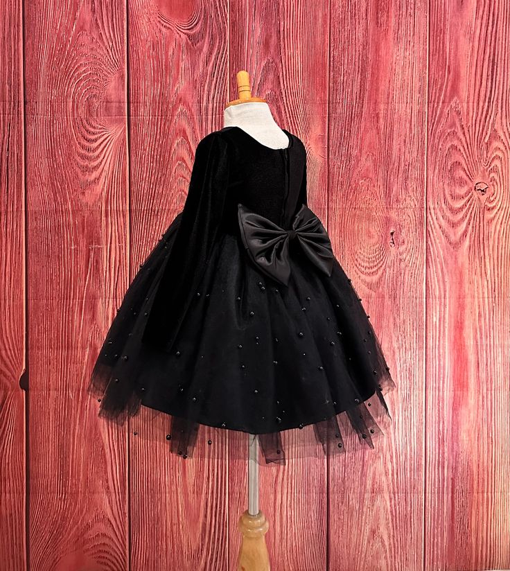 Little Darln Boutique  Our enchanting Knee Length flower girl dresses are sure to turn heads! This beautiful elegant sophisticated dress is handmade, the bodice consists of soft black velvet material, the back of the dress consists of a black satin detachable bow, with zipper for closure. The skirt consists of 4 Black layers of tulle with the top layer consisting with sowed in pearl beads. The fifth layer is made of lining with crinoline for fullness.  Dress Is Pictured with a petticoat NOT INCLUDED https://www.etsy.com/listing/1316417982/white-knee-length-petticoat-wedding?click_key=41cb8b0ae4587efa582b0a433f3f5e0cde12aec0%3A1316417982&click_sum=af1df37b&ref=shop_home_active_1 Visit our store, more items to come!  https://www.etsy.com/shop/LittledarlnBoutique?ref=profile_header CUSTOM MEA Christmas Wedding Flowers, Black Flower Girl Dress, Photoshoot Birthday, Kids Christmas Dress, Elegant Wedding Flowers, Toddler Girl Fall, Toddler Christmas Dress, Princess Dress Kids, Elegant Black Dress