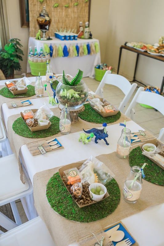 a table set up with plates and place settings for an animal themed baby's first birthday party