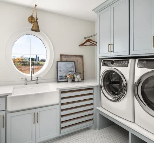 a washer and dryer in a small room with large windows on the wall