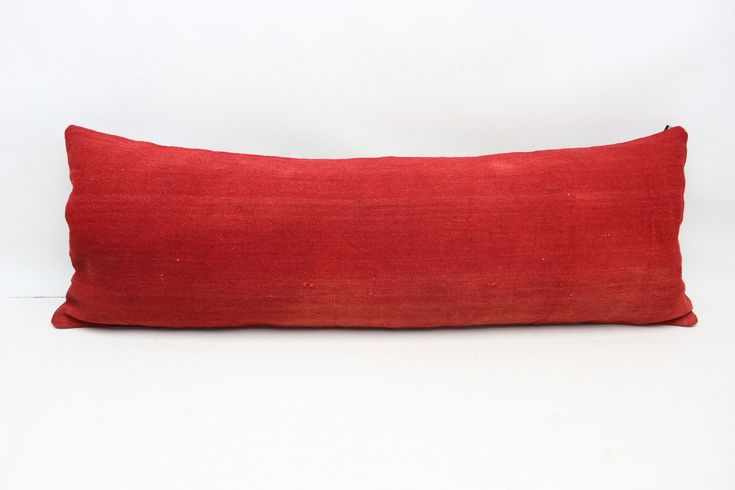 a red pillow sitting on top of a white table