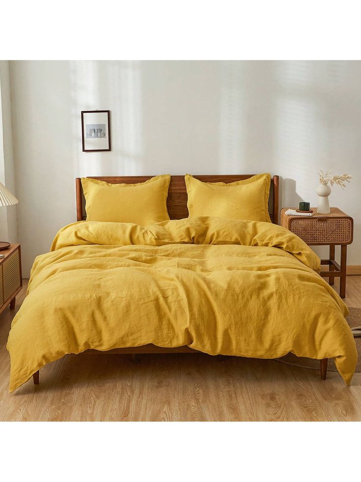 a bed with yellow sheets and pillows in a room