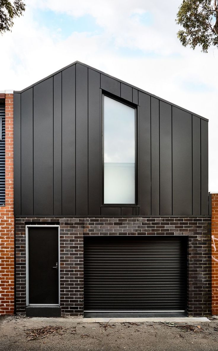 a brick building with black garage doors and windows