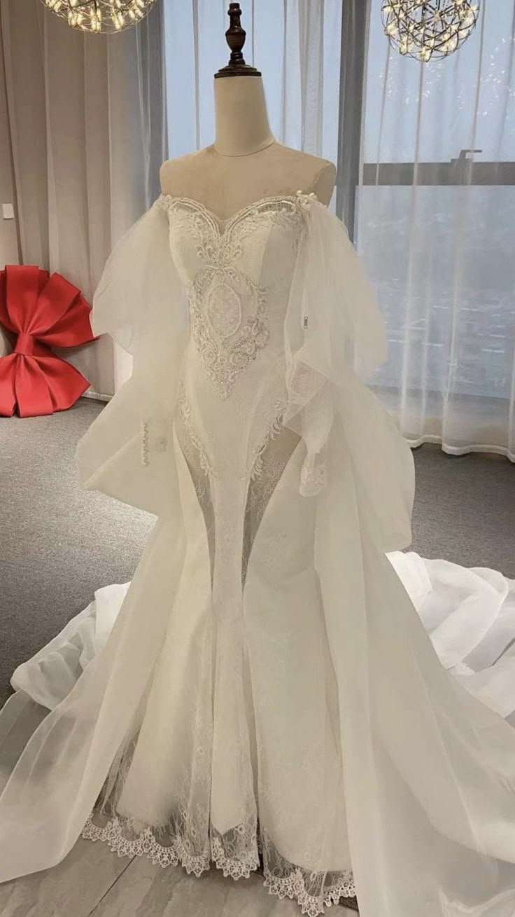 a wedding dress on display in front of a window