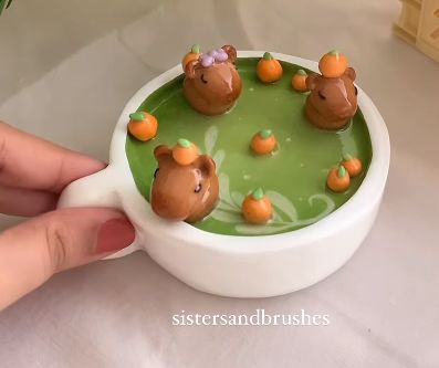 a person is holding a cup with chocolate bears in it