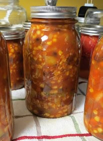 several jars filled with food sitting on top of a checkered tablecloth covered table