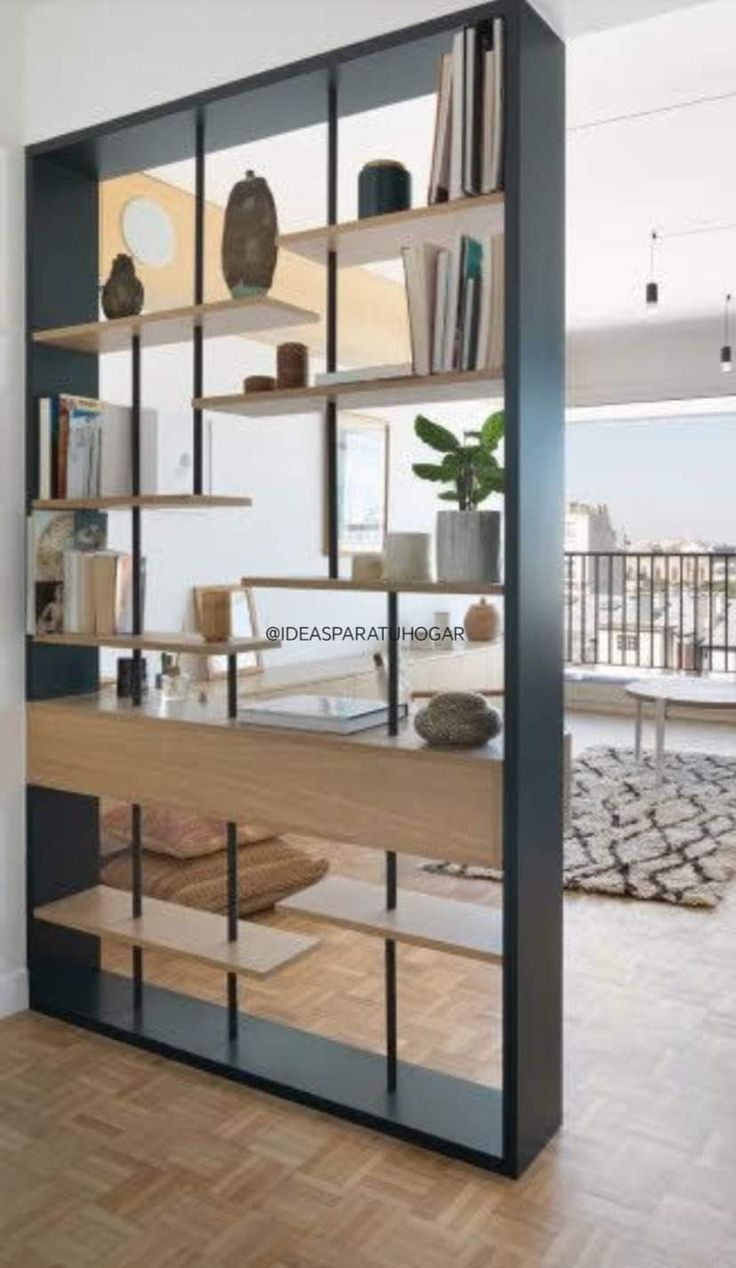 an open book shelf in the corner of a room with wooden floors and white walls