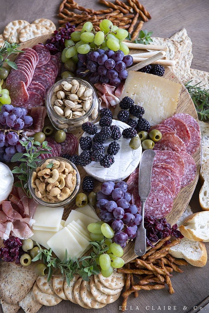 an assortment of cheeses, crackers, and meats on a platter