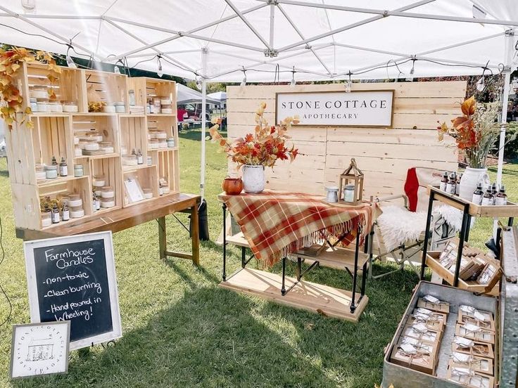 an outdoor market with tables and chairs under a white tent that says stone cottage on it