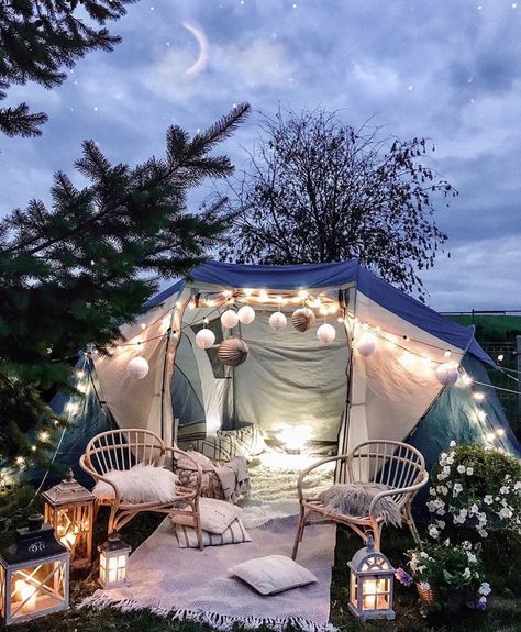 an outdoor tent is lit up with fairy lights