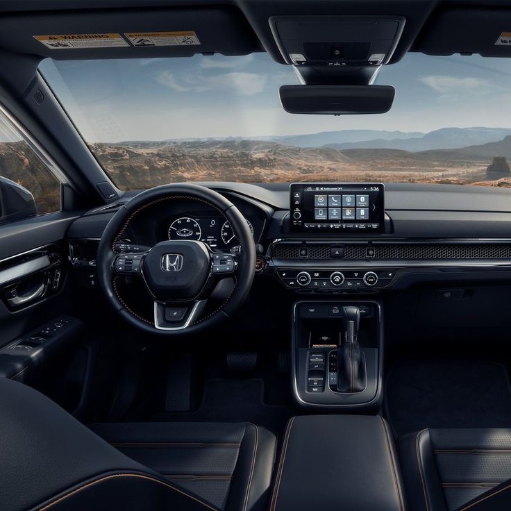 the interior of a car with black leather seats and steering wheel, dashboard, dash lights, and touchscreens