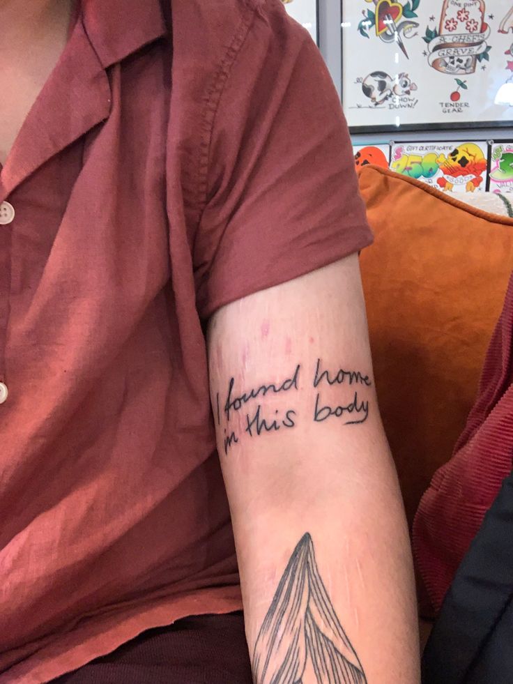 a person with a tattoo on their arm that says,'i am not home in this body '