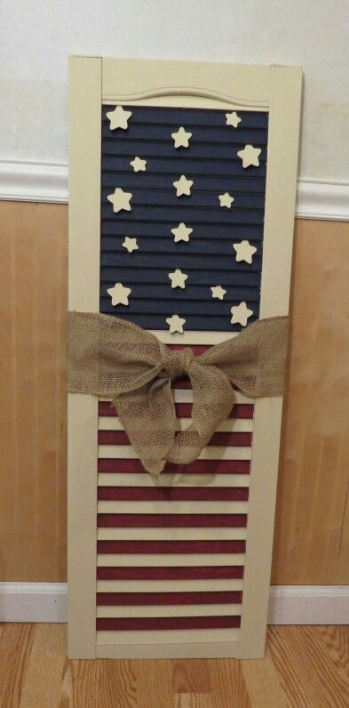 an american flag made out of shutters with a bow