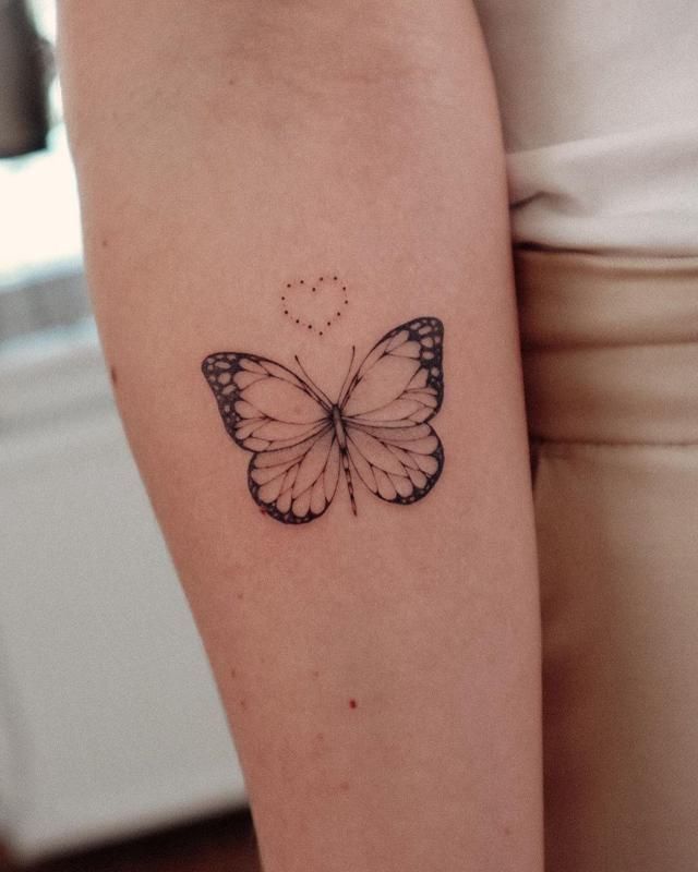 a small butterfly tattoo on the right arm and leg, with dots in it's wings