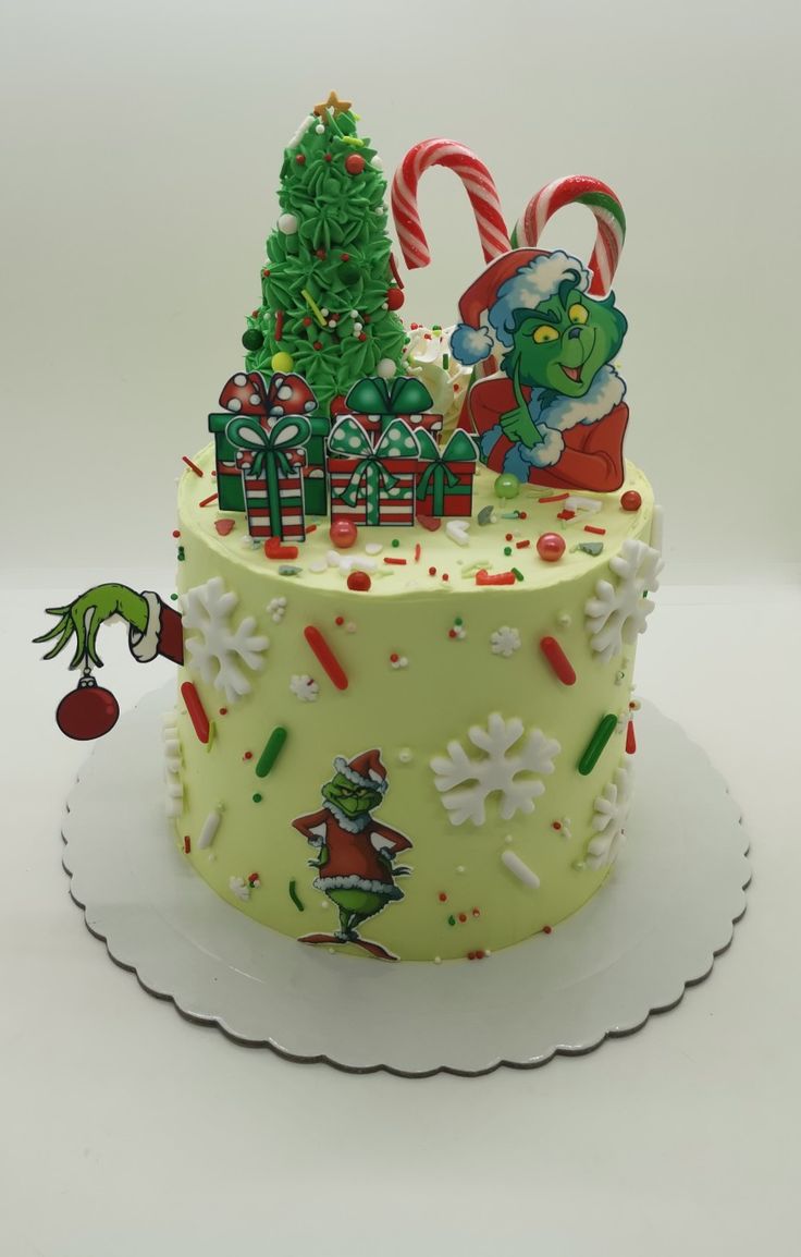 there is a cake decorated to look like the grinch and christmas tree with candy canes on it