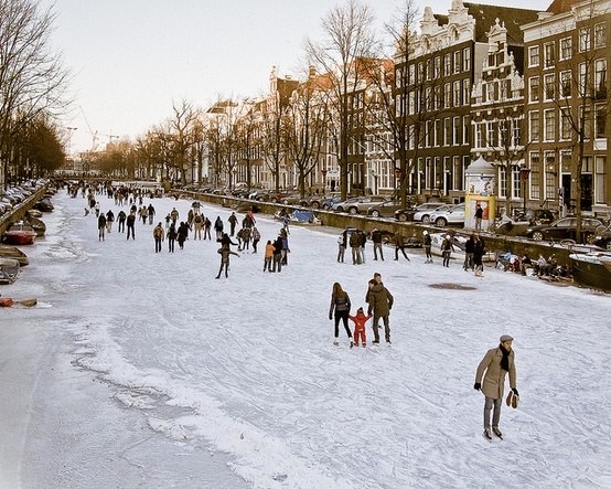 many people are walking in the snow near buildings