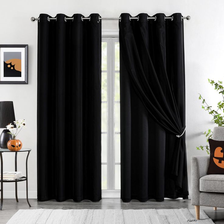 a living room filled with furniture and black curtains