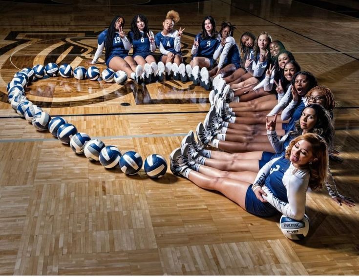 a group of cheerleaders sitting on top of a basketball court