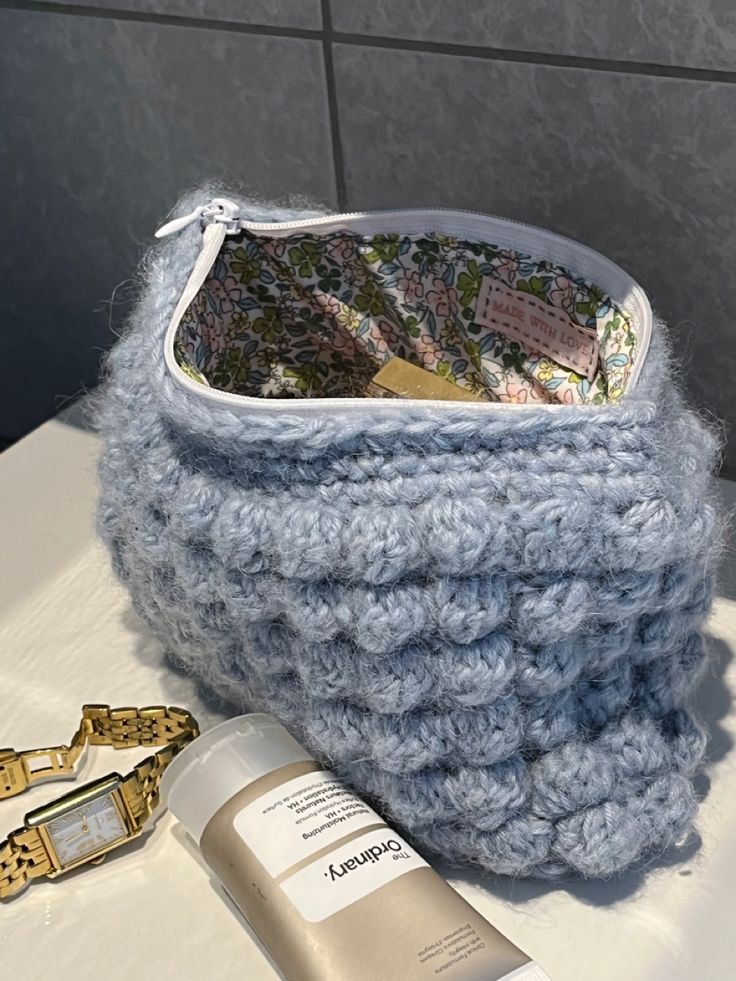 a blue knitted basket sitting on top of a table