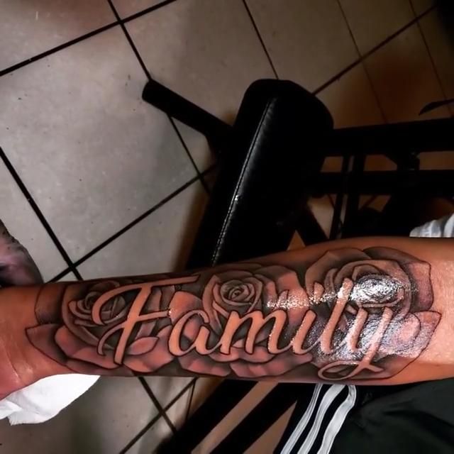 a man's arm with the word family tattooed on it