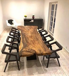 a large wooden table with chairs around it in a room that has hardwood floors and white walls