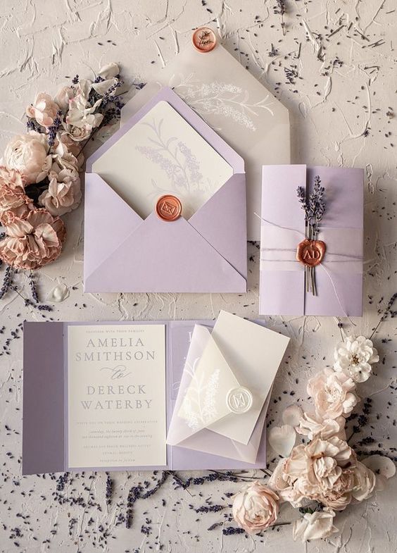 the wedding stationery is laid out on top of each other with flowers around it